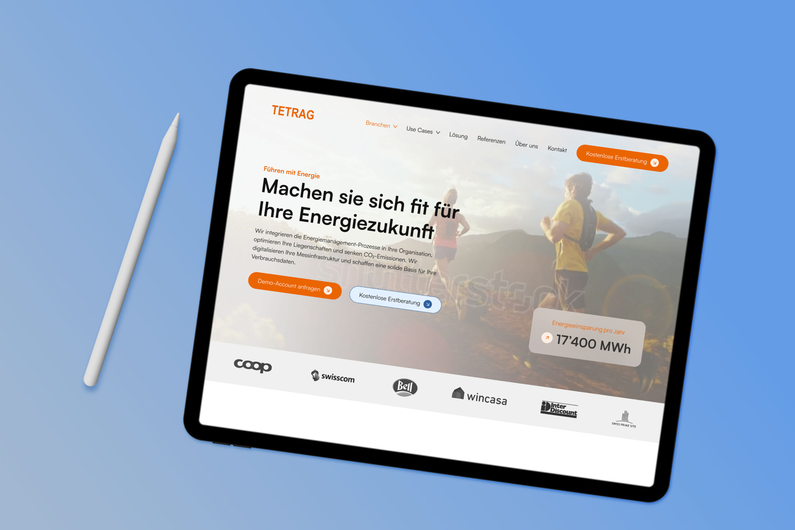 Ein Tablet und ein Stift auf einer blauen Oberfläche zeigen eine deutschsprachige Website eines Energieunternehmens mit einem Berghintergrund und Informationen über Energiedienstleistungen.