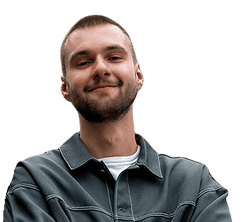 Ein junger Mann mit kurzen Haaren und Bart lächelt mit verschränkten Armen und trägt eine graue Jacke über einem weißen Hemd, isoliert auf einem transparenten Hintergrund.